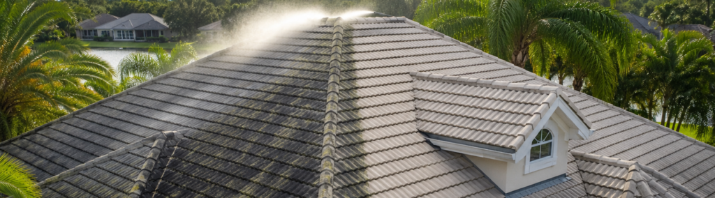 Professional low pressure roof cleaning service removing algae and stains from a Florida tile roof with gentle misting treatment